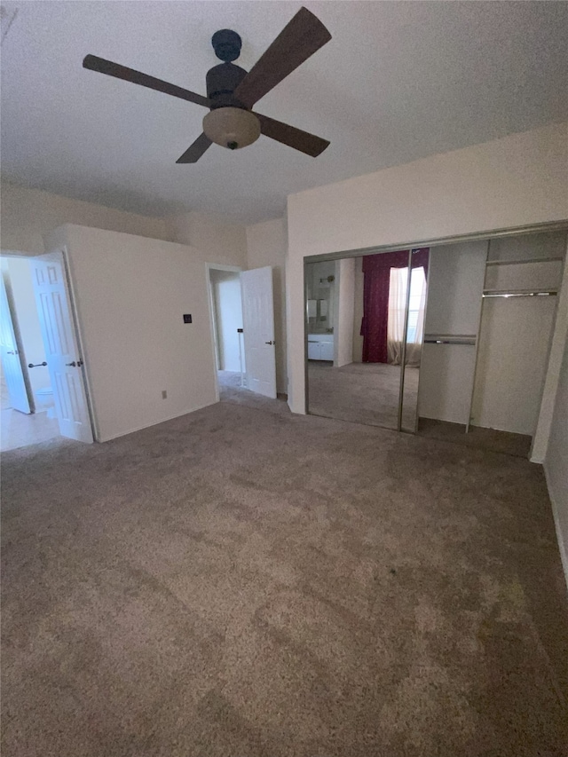 unfurnished bedroom featuring ceiling fan, a closet, carpet, and a textured ceiling