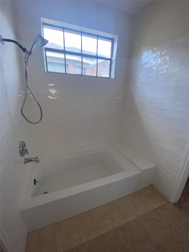 bathroom with tile patterned flooring, tiled shower / bath, and a wealth of natural light