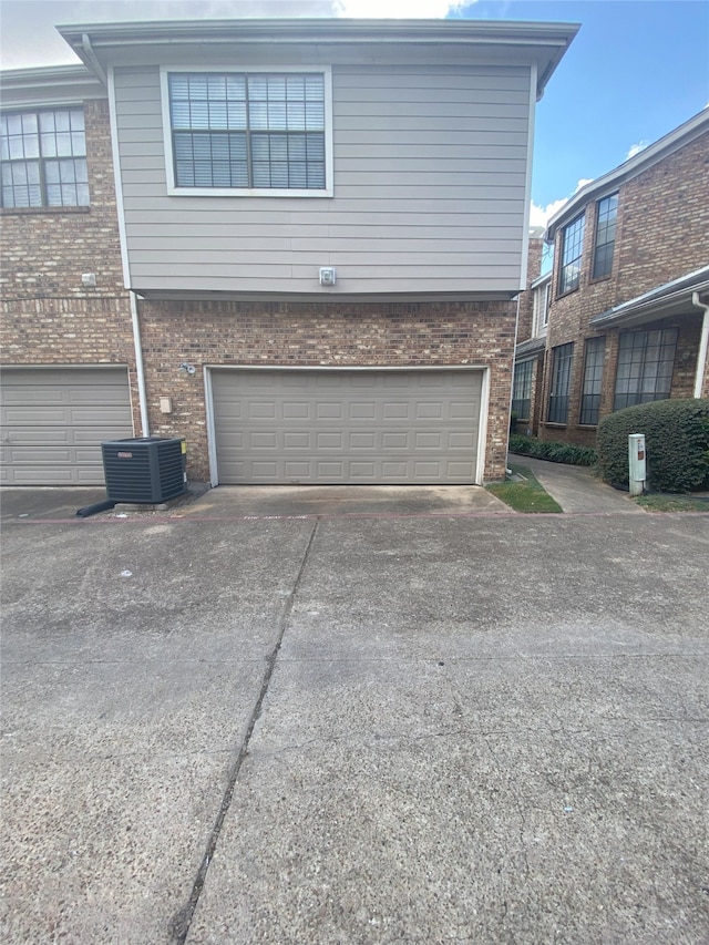 view of side of home with central AC unit and a garage