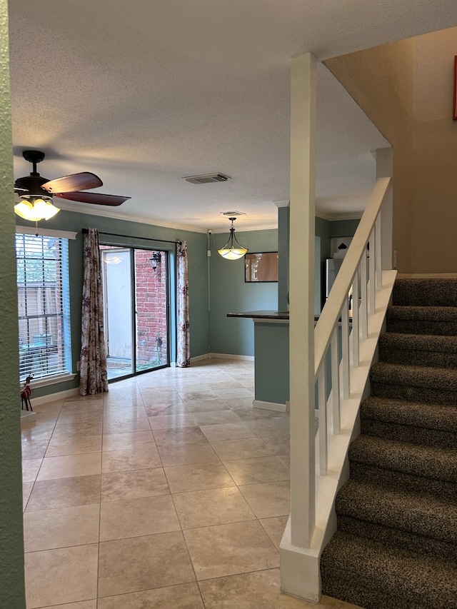 interior space featuring tile patterned floors, ceiling fan, and a textured ceiling