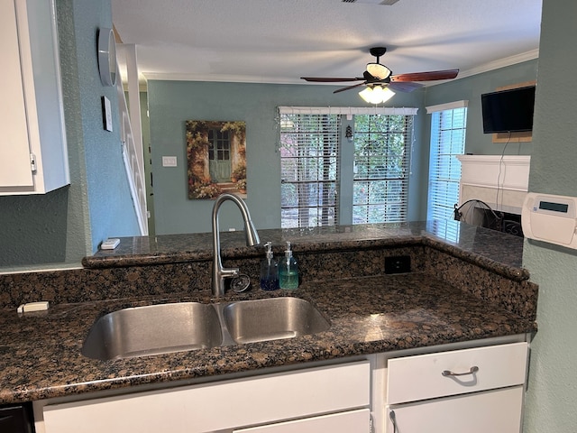 kitchen with ceiling fan, white cabinetry, sink, and dark stone counters