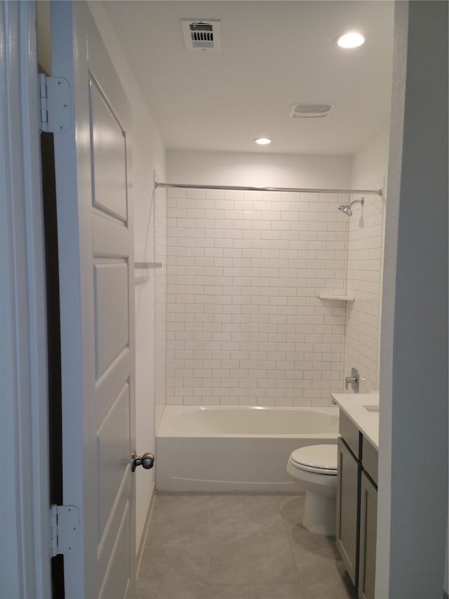 full bathroom featuring tiled shower / bath, tile patterned floors, vanity, and toilet