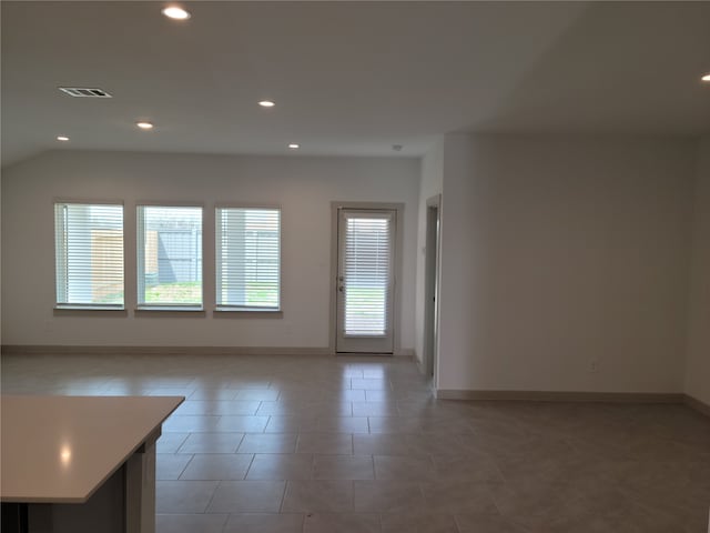 tiled spare room with lofted ceiling