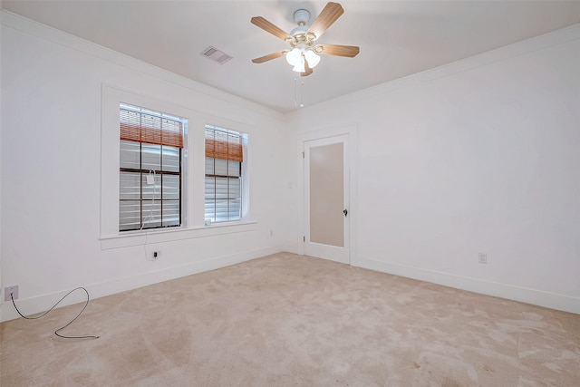 carpeted empty room featuring ceiling fan and crown molding