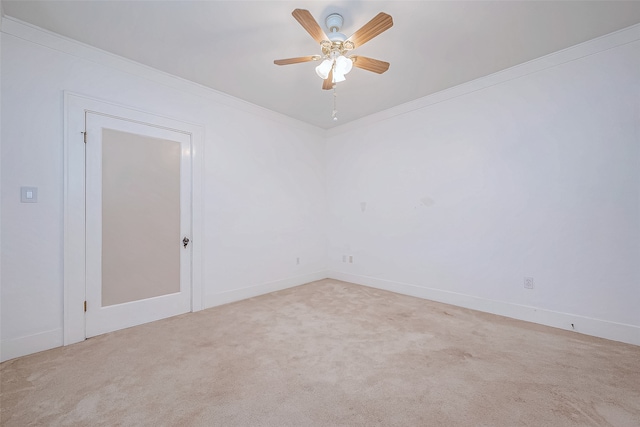 carpeted spare room featuring ceiling fan and crown molding