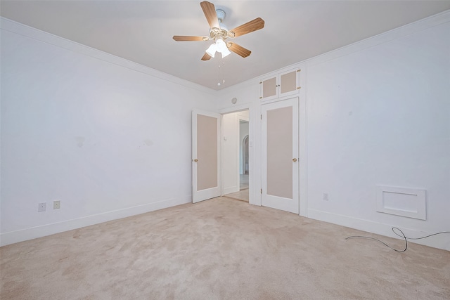 unfurnished room with light colored carpet, ceiling fan, and crown molding