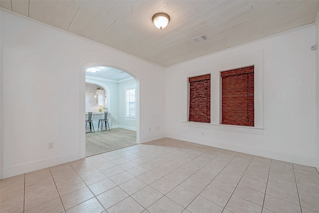 empty room with ornamental molding, wood ceiling, and light tile patterned flooring