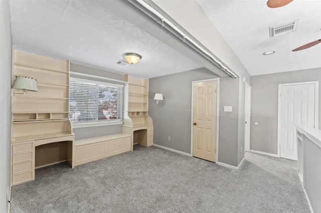 unfurnished bedroom with a textured ceiling, light carpet, and vaulted ceiling