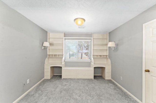 unfurnished bedroom with light colored carpet and a textured ceiling