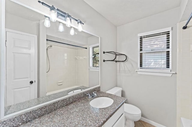 full bathroom featuring tile patterned floors, vanity, tiled shower / bath combo, and toilet