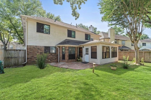 back of property with a lawn and a patio area