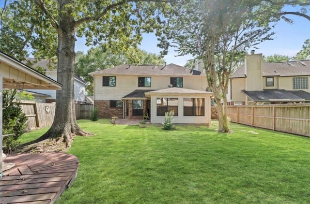 rear view of property featuring a lawn