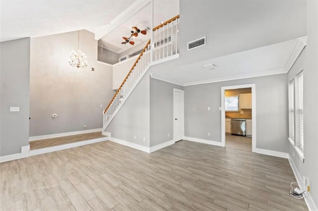 unfurnished living room featuring ornamental molding, hardwood / wood-style floors, and a notable chandelier