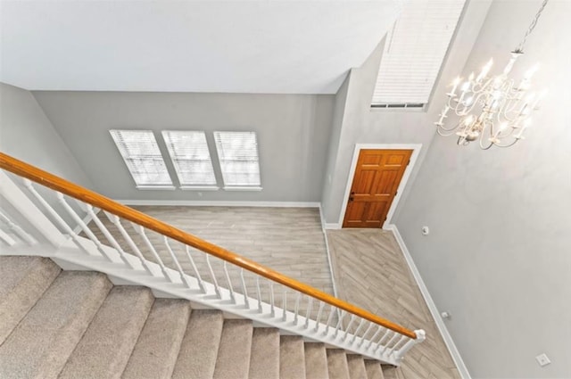 stairs with a notable chandelier and hardwood / wood-style flooring