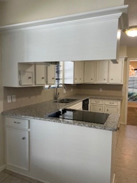 kitchen featuring light stone countertops, a healthy amount of sunlight, sink, and light tile patterned flooring