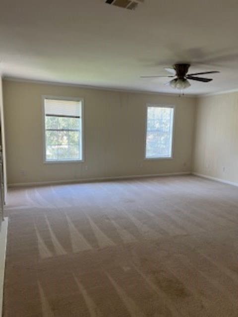 carpeted spare room with ornamental molding and ceiling fan