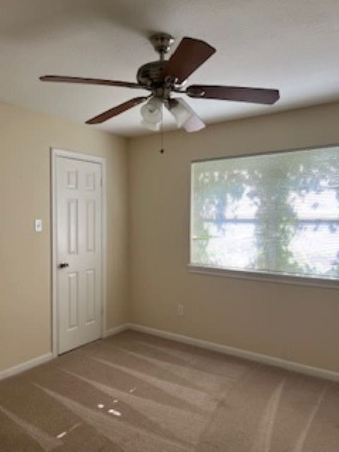 carpeted spare room with ceiling fan