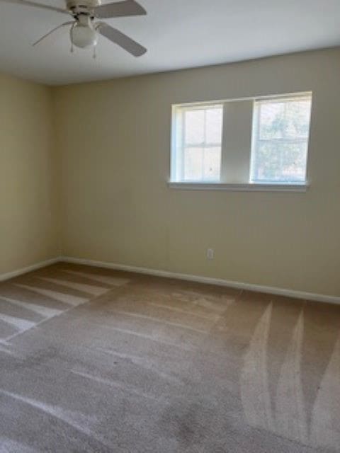 carpeted empty room featuring ceiling fan