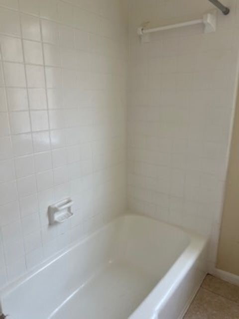 bathroom featuring tile patterned flooring and tiled shower / bath combo