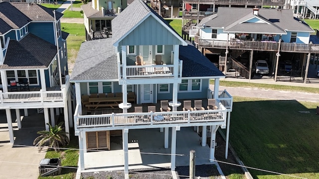 back of house featuring a balcony and a carport