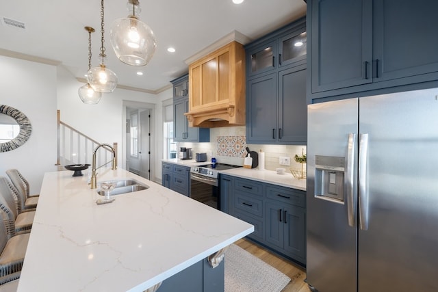 kitchen with appliances with stainless steel finishes, blue cabinets, and a breakfast bar area