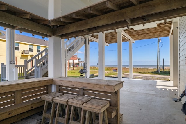 view of patio / terrace featuring a water view and exterior bar