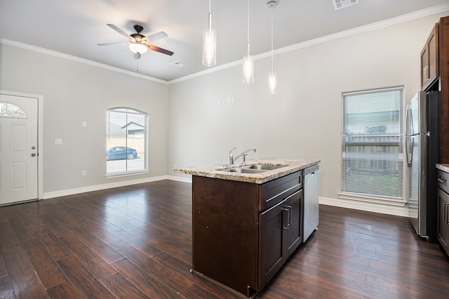 kitchen with stainless steel appliances, a center island with sink, sink, decorative light fixtures, and dark hardwood / wood-style flooring