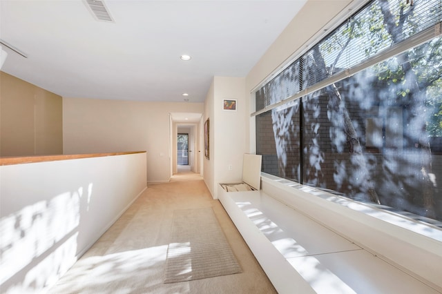 hall featuring light colored carpet