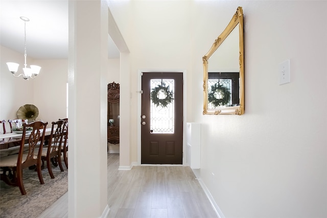 entrance foyer featuring light hardwood / wood-style flooring and a notable chandelier