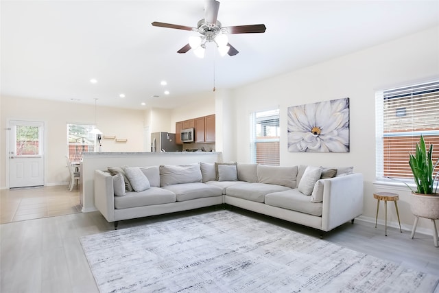 living room featuring light hardwood / wood-style floors and ceiling fan