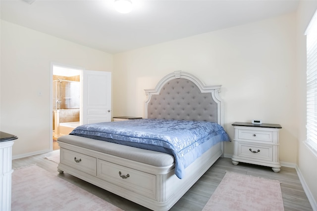 bedroom with light hardwood / wood-style floors and ensuite bathroom