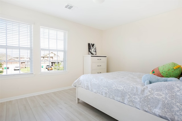 bedroom featuring light hardwood / wood-style flooring and multiple windows