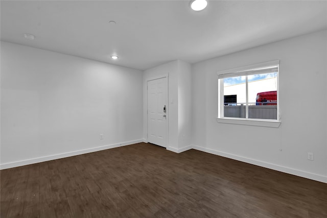 spare room with dark wood-type flooring