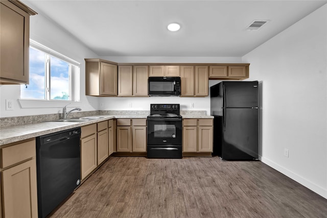 kitchen featuring black appliances, sink, and wood-type flooring