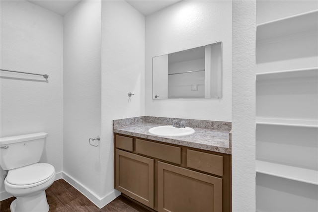 bathroom featuring toilet, vanity, and hardwood / wood-style floors