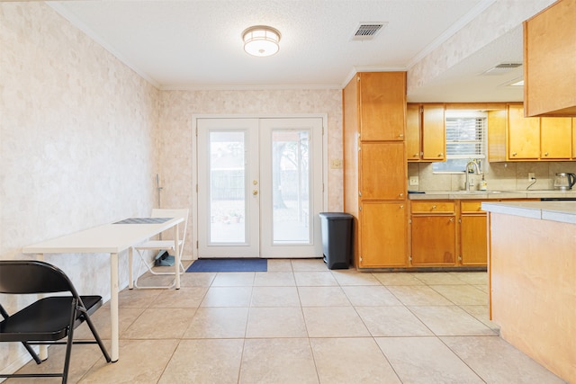 kitchen featuring a healthy amount of sunlight, sink, french doors, and crown molding