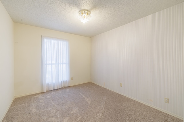 carpeted spare room with a textured ceiling