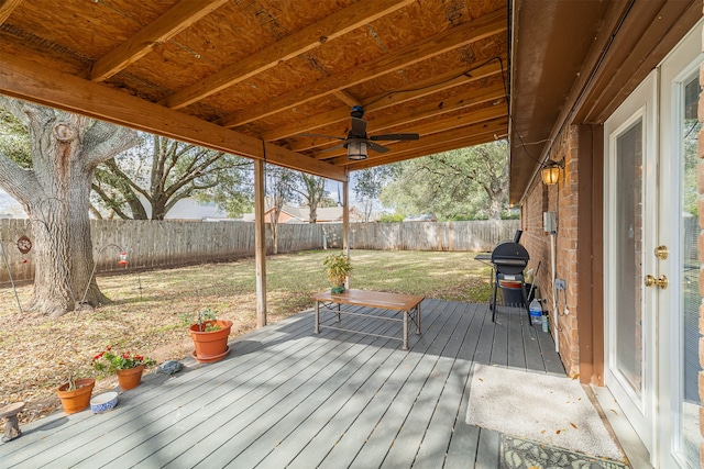 wooden terrace with grilling area, a yard, and ceiling fan