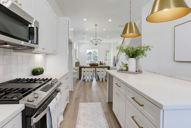 kitchen featuring appliances with stainless steel finishes, light hardwood / wood-style floors, and white cabinets