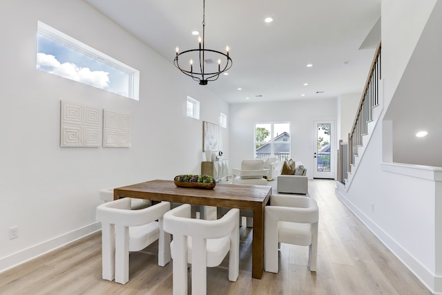 dining room with light wood-type flooring and a chandelier