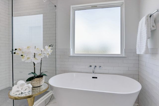 bathroom featuring a bathtub and tile walls