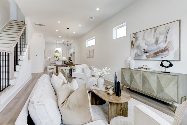 living room featuring light hardwood / wood-style flooring and a notable chandelier