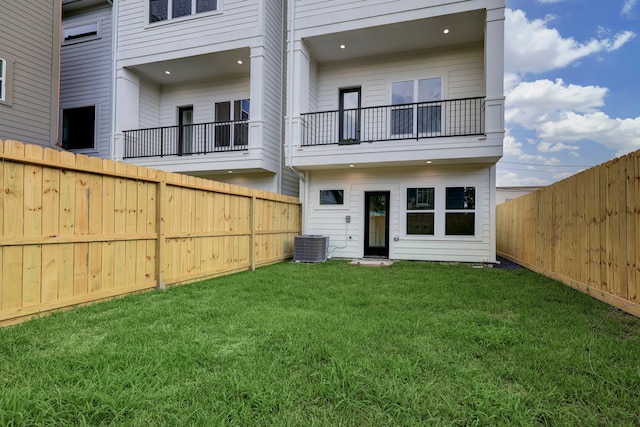 back of property featuring central AC unit, a yard, and a balcony