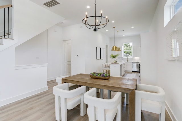 dining area featuring light hardwood / wood-style floors, a chandelier, and sink