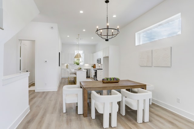 dining area with an inviting chandelier and light hardwood / wood-style floors