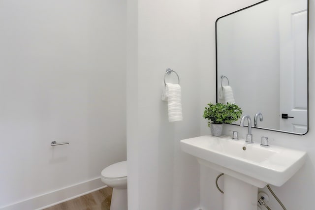 bathroom with toilet and hardwood / wood-style floors