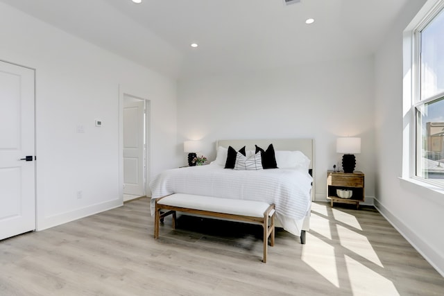 bedroom with light wood-type flooring and multiple windows