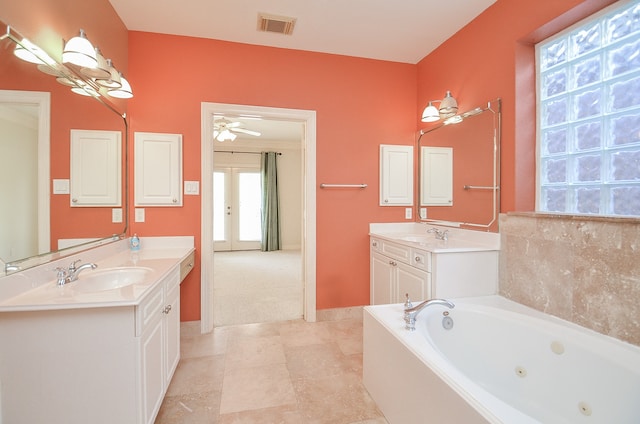 bathroom with tile patterned flooring, vanity, ceiling fan, and a tub