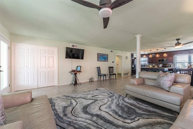 living room featuring rail lighting, decorative columns, and ceiling fan