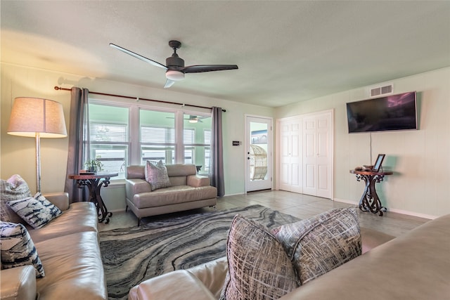 living room featuring ceiling fan, light tile patterned floors, and a textured ceiling